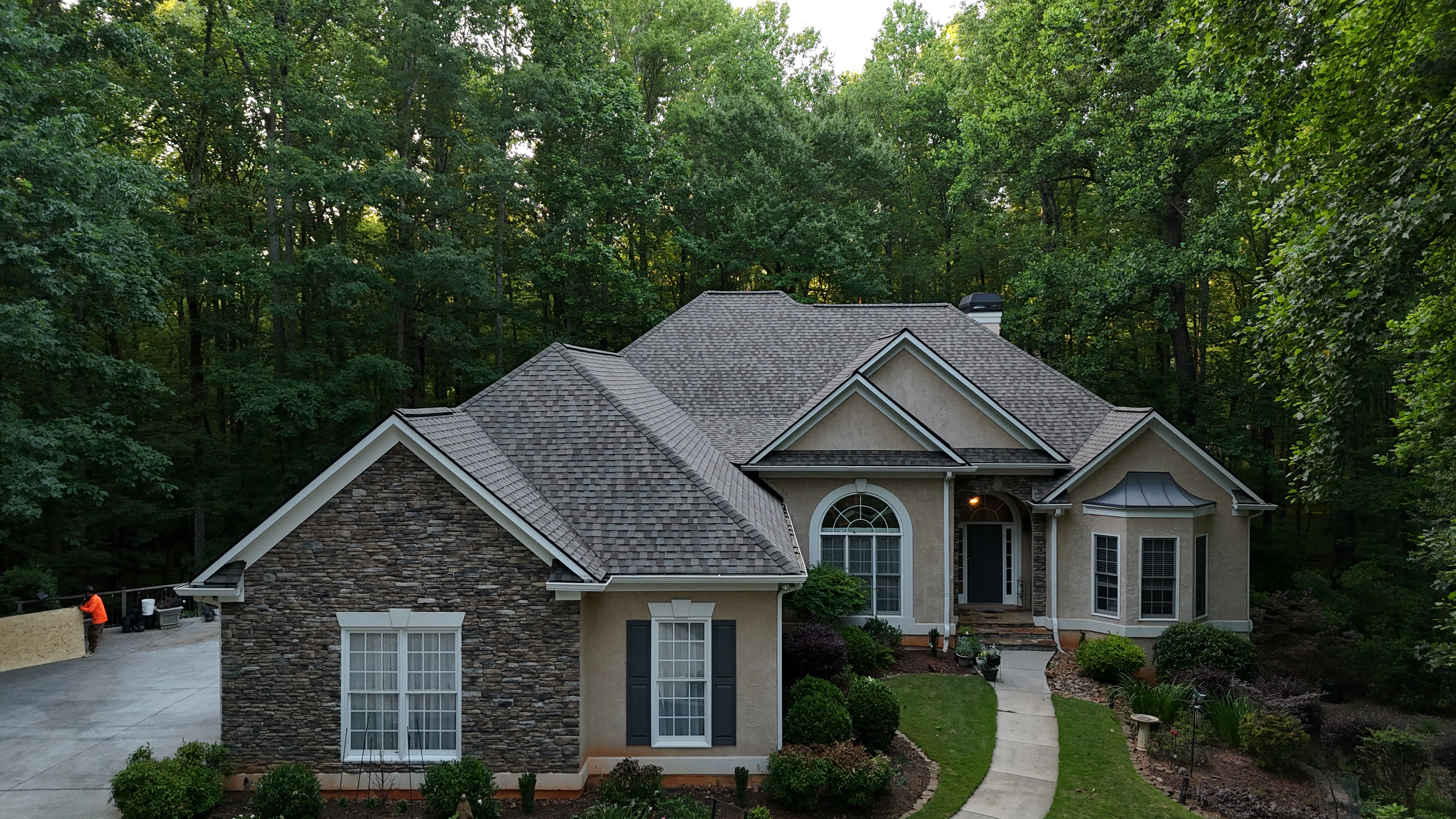 Roofing crew mid-tearoff on gray house — metro Atlanta